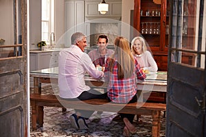 Family With Adult Offspring Enjoying Meal At Home Together