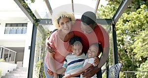 Family of African American father embraces a young biracial mother and two cheerful children