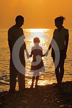 Family against glossing sea. Parents and daughter photo