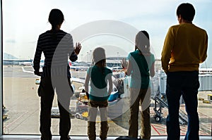 Family in airport, travel concept, silhouettes of parents with kids in terminal waiting for flight