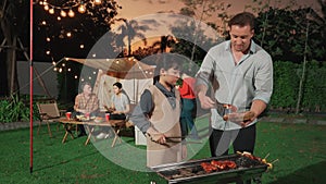 Family all together camp in garden, father and daughter grill food. Divergence.