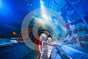 Family in aquarium. Kids watch fish, marine life