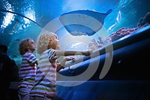 Family in aquarium. Kids watch fish, marine life