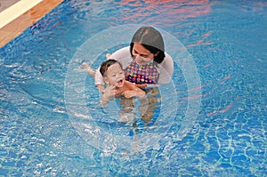 Family of Asian mother teaching baby boy swimming pool