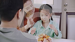 Family Asian people are happy to eat enjoy tasty pizza at home. Parents and daughter eating delicious Italian food from takeaway d