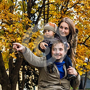 Family in autumn park hand show afar