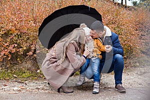 Family autumn in the Park in the rain umbrella