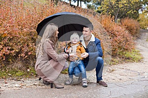 Family autumn in the Park in the rain umbrella