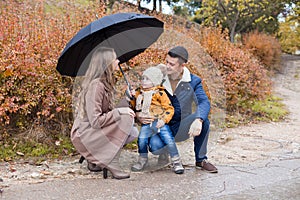 Family autumn in the Park in the rain umbrella