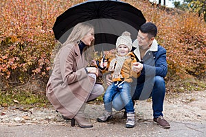 Family autumn in the Park in the rain umbrella