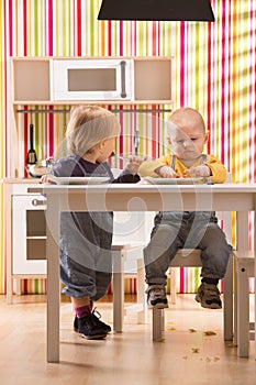 Family baby brother and sister play eat meal in toy kitchen