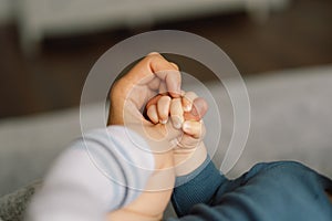 Family Baby Hands. Closeup of baby hand into mother hands.