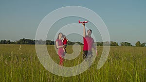 Family with baby playing with model plane in nature