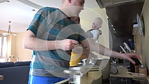 Family with baby prepare dinner in kitchen. Mom taste soup spoon