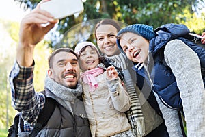 Family with backpacks taking selfie by smartphone