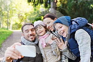 Family with backpacks taking selfie by smartphone