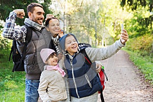 Family with backpacks taking selfie by smartphone