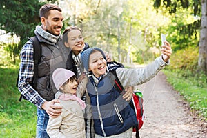 Family with backpacks taking selfie by smartphone