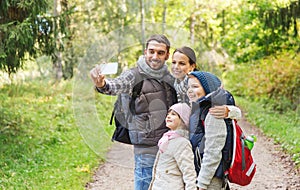 Family with backpacks taking selfie by smartphone