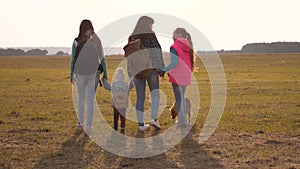 Family with backpacks travels with a dog. teamwork of a close-knit family. mother, daughters and home pets tourists