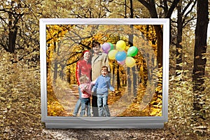 Family with balloons in autumnal park in unreal tv