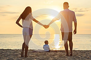 Family on the beach concept, Caucasian boy siting and holding sa