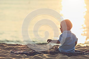 Family on the beach concept, Caucasian boy siting and holding sa