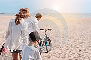 Family on the beach they are enjoy bicycle. Happy father, mother and son, daughter enjoying road trip the summer holidays.Parents