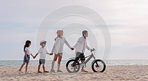 Family on the beach they are enjoy bicycle. Happy father, mother and son, daughter enjoying road trip the summer holidays.Parents