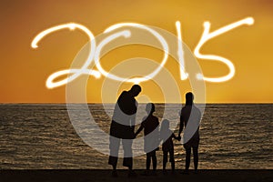 Family on beach enjoy new year 2015