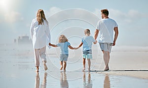 Family, beach and holding hands while walking in water on summer vacation with parents and children together for love