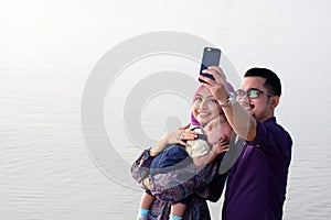 family at beach making a self portrait with a mobile phone