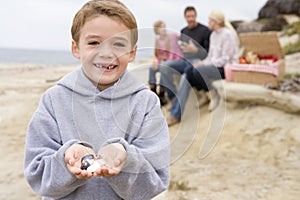 Family at beach with picnic and boy smiling