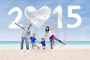 Family at beach under cloud of 2015