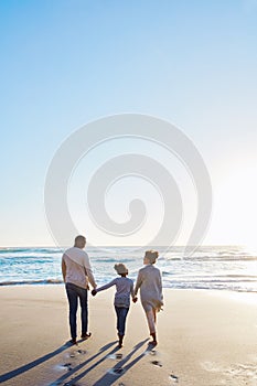 Family, beach and walk during sunset on vacation or holiday relaxing and enjoying peaceful scenery at the ocean. Sea