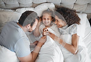 Family, bed and parents laughing with their daughter in the morning to relax after waking up together. Kids, love or