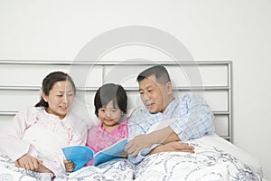 Family in Bed Reading