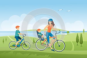 Family bike ride in summer green landscape and nature, mother and children on bicycles