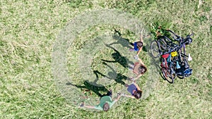 Family on bikes cycling outdoors, active parents and kids on bicycles, aerial top view of happy family with children