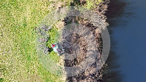 Family on bikes cycling outdoors, active parents and kids on bicycles, aerial view of family with children relaxing