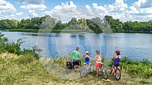 Family on bikes cycling outdoors, active parents and kids on bicycles, aerial view of happy family with children relaxing