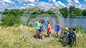 Family on bikes cycling outdoors, active parents and kids on bicycles, aerial view of happy family with children relaxing