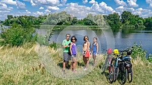 Family on bikes cycling outdoors, active parents and kids on bicycles, aerial view of happy family with children relaxing