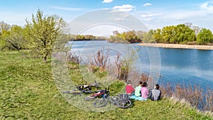 Family on bikes cycling outdoors, active parents and kids on bicycles, aerial view of happy family with children relaxing