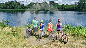 Family on bikes cycling outdoors, active parents and kids on bicycles, aerial view of happy family with children relaxing photo