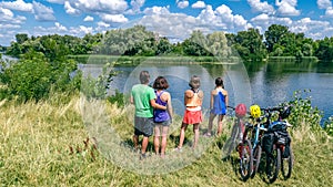 Family on bikes cycling outdoors, active parents and kids on bicycles, aerial view of happy family with children relaxing