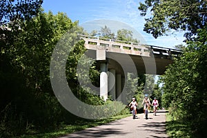 Family Biking Under Bridge