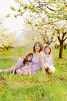 A family in a blossoming spring garden. mom and two daughters.