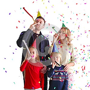 Family blowing party trumpets with confetti