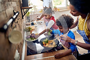 Family Bonding in the Kitchen: Mother Cooking with Kids While Father Takes Care of Dishes